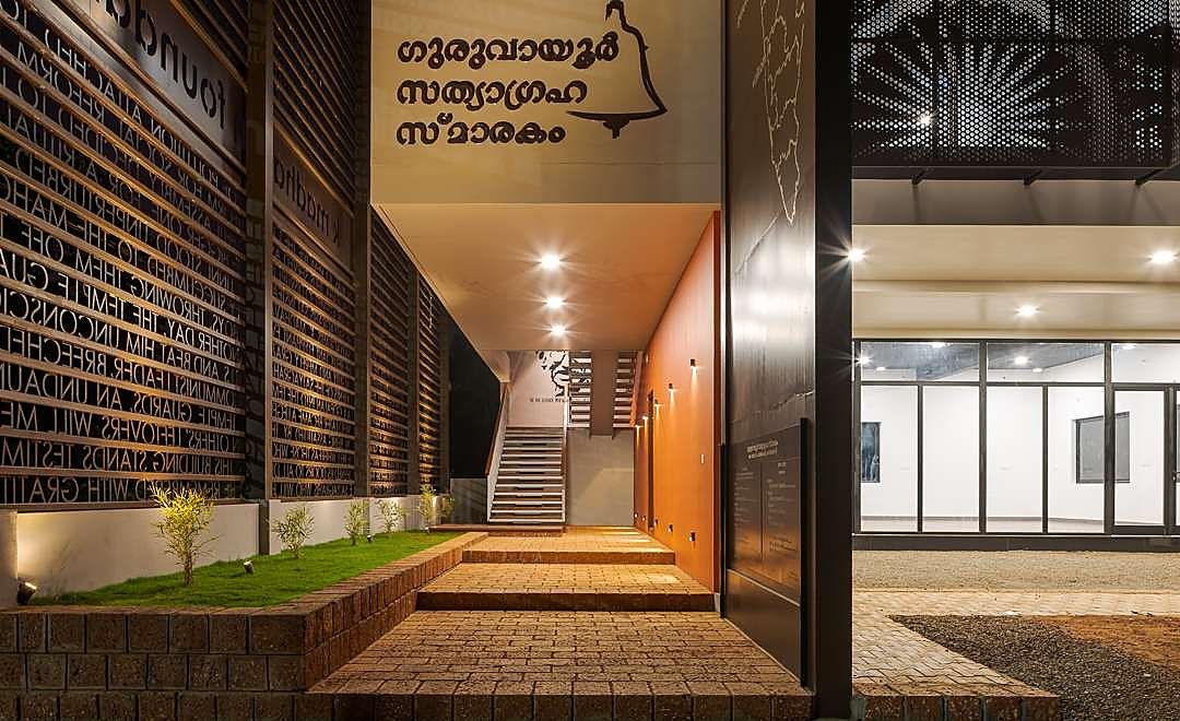 Entrance approach lit at night, with inscribed metal screens