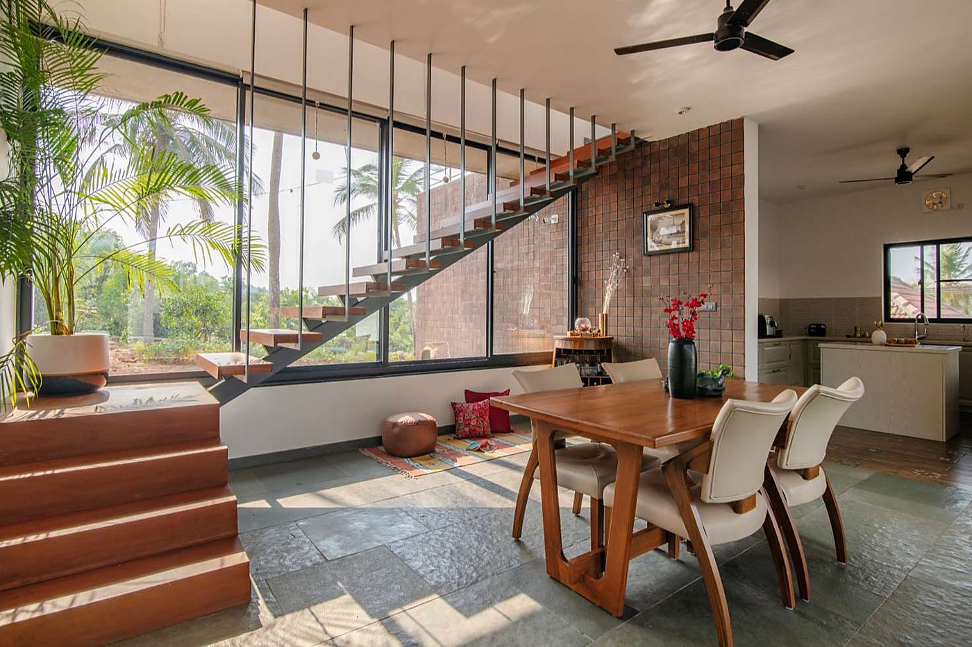 Dining area with floating stair and jaali brick wall